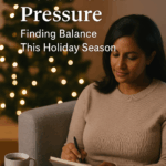 A professional woman in her 40s, with medium brown skin and dark hair, sits on a sofa near softly glowing holiday lights, journaling with a cup of tea beside her. The scene feels calm, warm, and reflective, symbolizing peace, mindfulness, and emotional balance during the holiday season